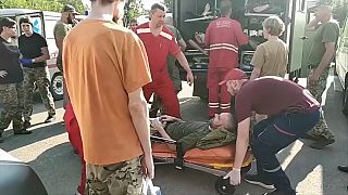 An injured Ukrainian prisoner being handed over on a stretcher
