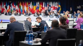 Le président français Emmanuel Macron s'entretient avec le chancelier allemand Olaf Scholz lors du sommet de l'OTAN à Madrid, 29 juin 2022. 