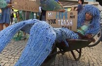 A woman protests dressed as a mermaid outside UN Ocean Conference in Lisbon.
