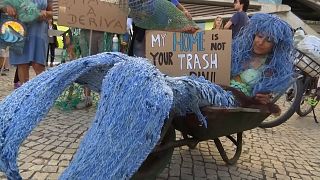 A woman protests dressed as a mermaid outside UN Ocean Conference in Lisbon.