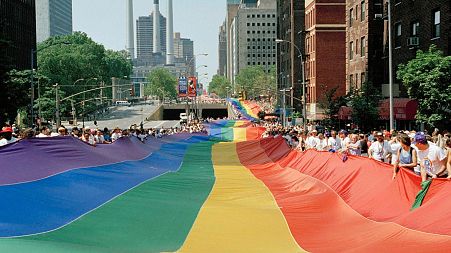 A mile-long rainbow is carried past the United Nations secretariat building during a march to commemorate the 25th anniversary of the stonewall riots Sunday, June 26, 1994
