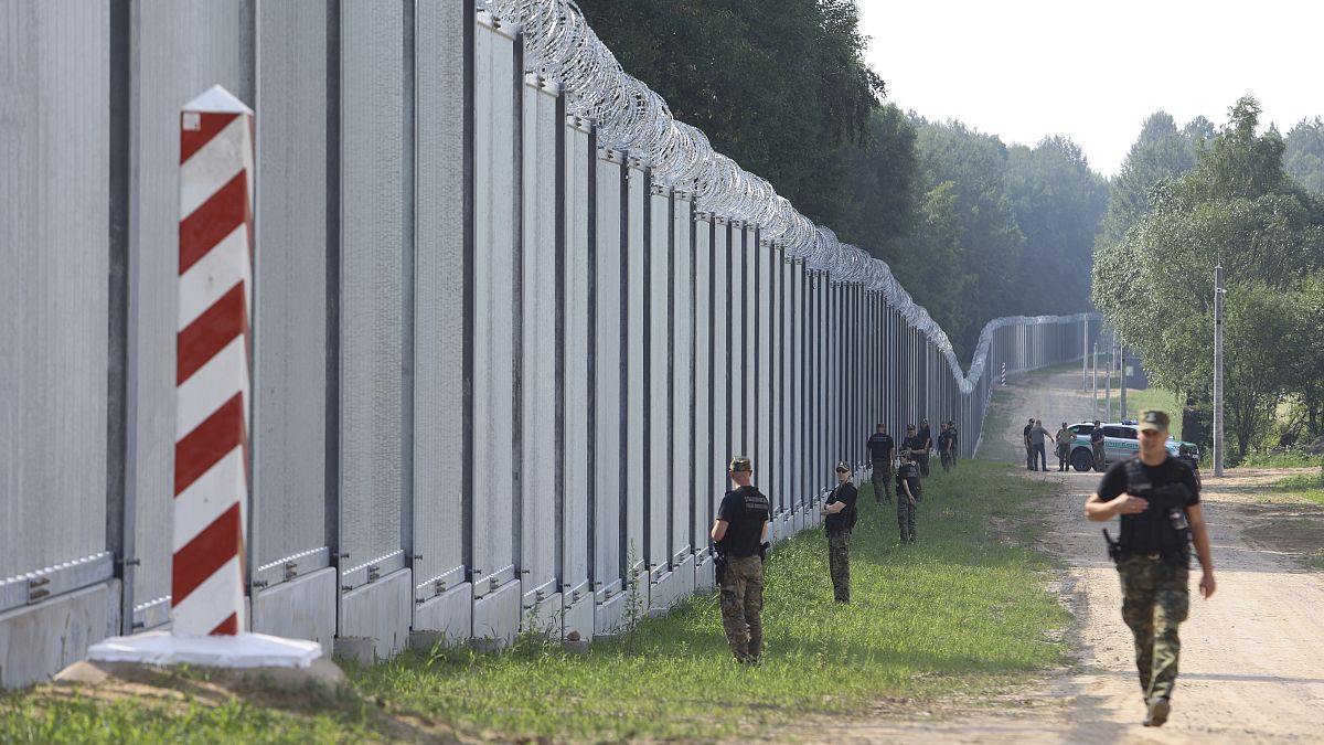 Polish border guards patrol the area of a newly built border wall near Kuznice.