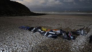 Life jackets and a damaged inflatable small boat on the shore in Wimereux, northern France.