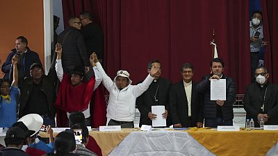 El representante del Gobierno, Francisco Jiménez, sostiene el acuerdo realizado con los líderes indígenas, Eustaquio Toala y Leonidas Iza en Quito, Ecuador, el 30 de junio