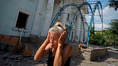 Une femme se couvre les oreilles lors d'un raid aérien russe à Lyssytchansk, 16 juin 2022.