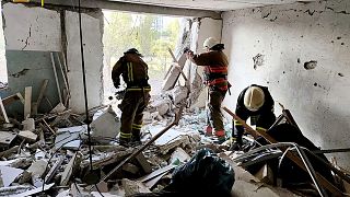 First responders work in a damaged residential building in Odesa, Ukraine, early Friday, July 1, 2022, following Russian missile attacks.