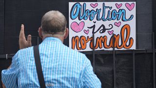 Un activista antiaborto frente a un cartel que dice que "El aborto es normal" fuera de la clínica de la Organización de Salud de la Mujer de Jackson, Mississippi, 30/6/2022