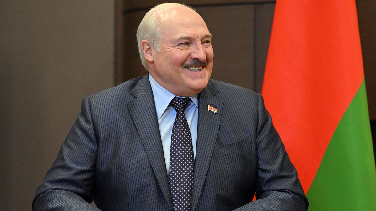 Belarusian President Alexander Lukashenko smiles while speaking to Russian President Vladimir Putin during their meeting in Sochi in May 2022