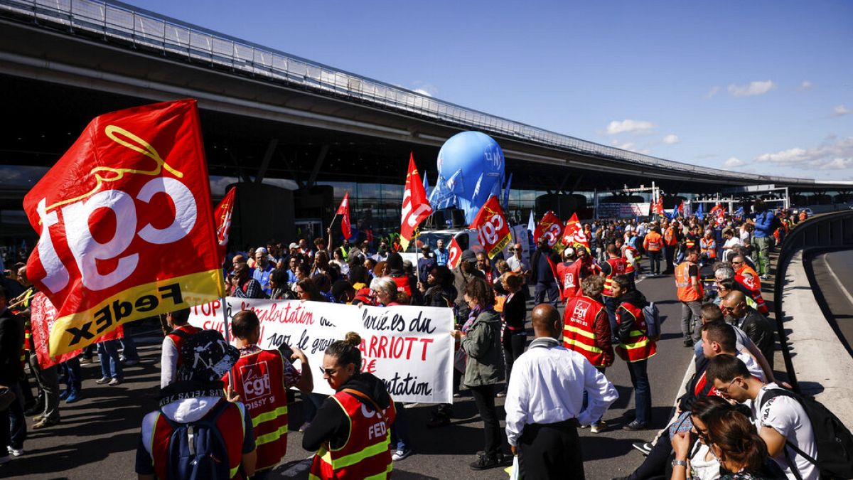 Unionists strikers demonstrate outside a terminal, July 1, 2022 at Roissy airport, north of Paris