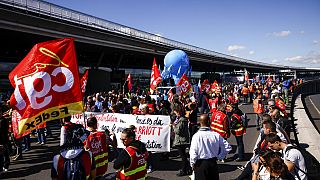 Unionists strikers demonstrate outside a terminal, July 1, 2022 at Roissy airport, north of Paris