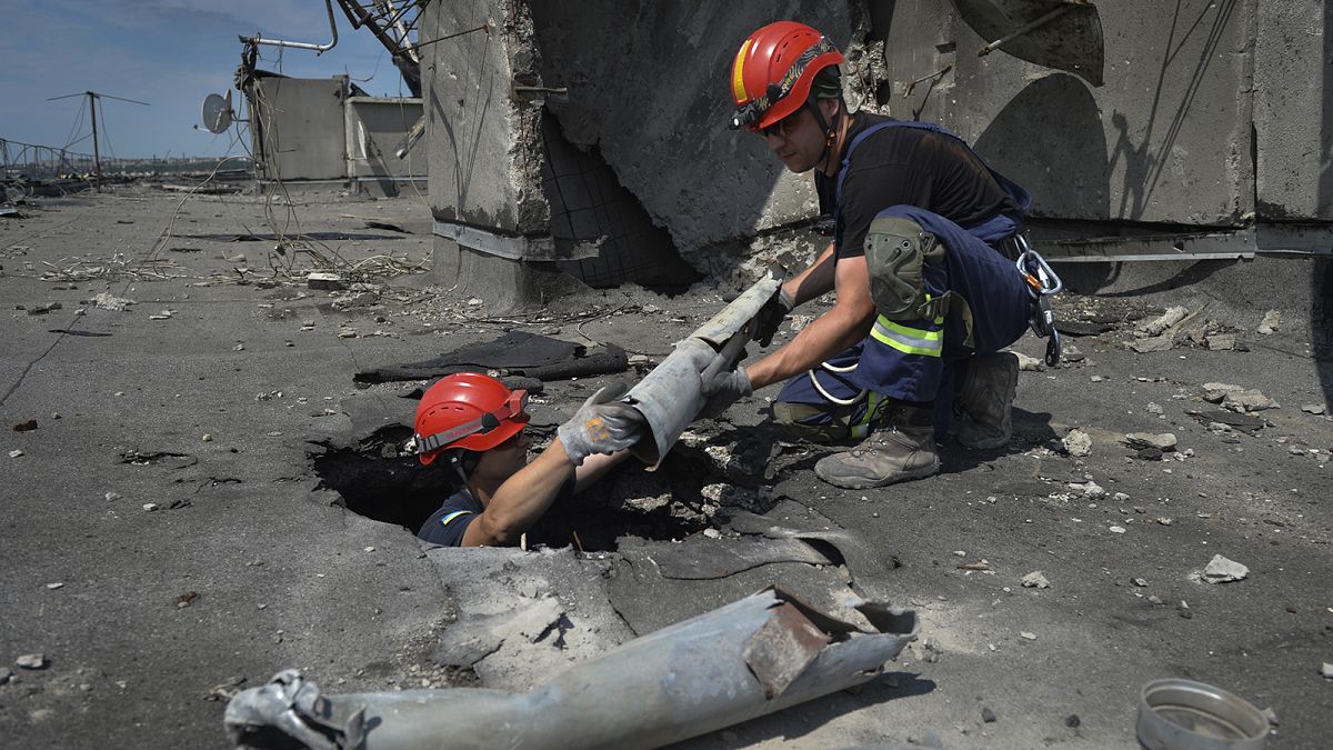 Ukrainian rescuers retrieve the remains of Russian shells on the roof of a high-rise damaged by Russian shelling in one of the residential areas of Kharkiv, 30 June 2022