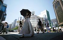 Japonya'nın başkenti Tokyo'da vatandaşlar, aşırı sıcaklardan korunmak için dışarıda şemsiye kullanıyor