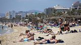 Turistas toman el sol en la playa de las Islas Baleares