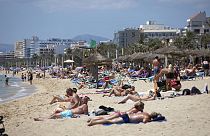 Turistas toman el sol en la playa de las Islas Baleares