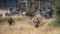 Des migrants traversant le grillage de l'enclave espagnole de Melilla, le 24 juin 2022