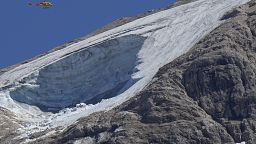 A rescue helicopter hoovers over the Punta Rocca glacier near Canazei, in the Italian Alps in northern Italy, July 4, 2022, a day after a huge chunk of the glacier broke loose