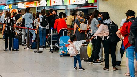 Passengers queue in Lisbon international airport in 2018