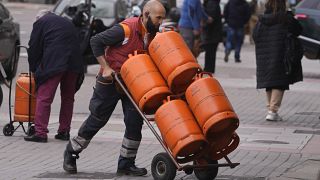 ARCHIVO - Un trabajador reparte botellas de gas butano en Madrid, España, el lunes 28 de marzo de 2022