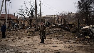 صورة أرشفية لامرأة تقف وسط الدمار الذي سببته الحرب في بوتشا بضواحي العاصمة كييف، أوكرانيا، 5 أبريل 2022.
