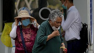 Eine Frau reagiert auf das Gefühl nach einem Rachenabstrich in einem Covid-Testzentrum in Peking. 