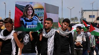 طلاب يحملون نعشًا وهميًا خلال جنازة رمزية لصحيفة الجزيرة المقتولة شيرين أبو عقلة في جامعة الأزهر في المغراقة وسط قطاع غزة.