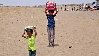 Yemenis displaced by the conflict, receive food aid and supplies to meet their basic needs, at a camp in Hays district.