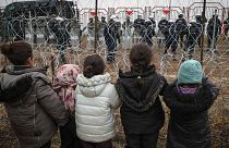 Migrantenkinder stehen polnischen Soldaten gegenüber am Kontrollpunkt "Kuznitsa" an der weißrussisch-polnischen Grenze bei Grodno, 17.11.21