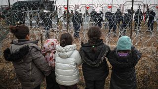Migrantenkinder stehen polnischen Soldaten gegenüber am Kontrollpunkt "Kuznitsa" an der weißrussisch-polnischen Grenze bei Grodno, 17.11.21