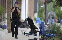A Lake County police officer walks down Central Avenue in downtown Highland Park, a Chicago suburb, after a mass shooting at the 4 July parade