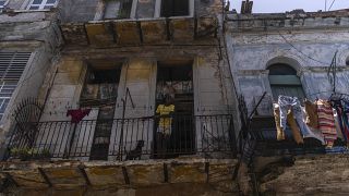 Anet Ayala y su perro se asoman desde su balcón en La Habana, Cuba, el lunes 13 de junio de 2022.