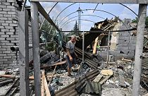 A resident walks among debris next to a destroyed house in Sloviansk on July 4, 2022, the day after a Russian rocket attack.