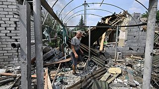 A resident walks among debris next to a destroyed house in Sloviansk on July 4, 2022, the day after a Russian rocket attack. 