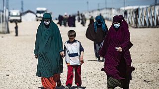 Des femmes avec des enfants marchent dans le camp de Roj, en Syrie, le 28 mars 2021