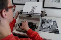 Artist James Cook using a typewriter to create a portrait of a dog 