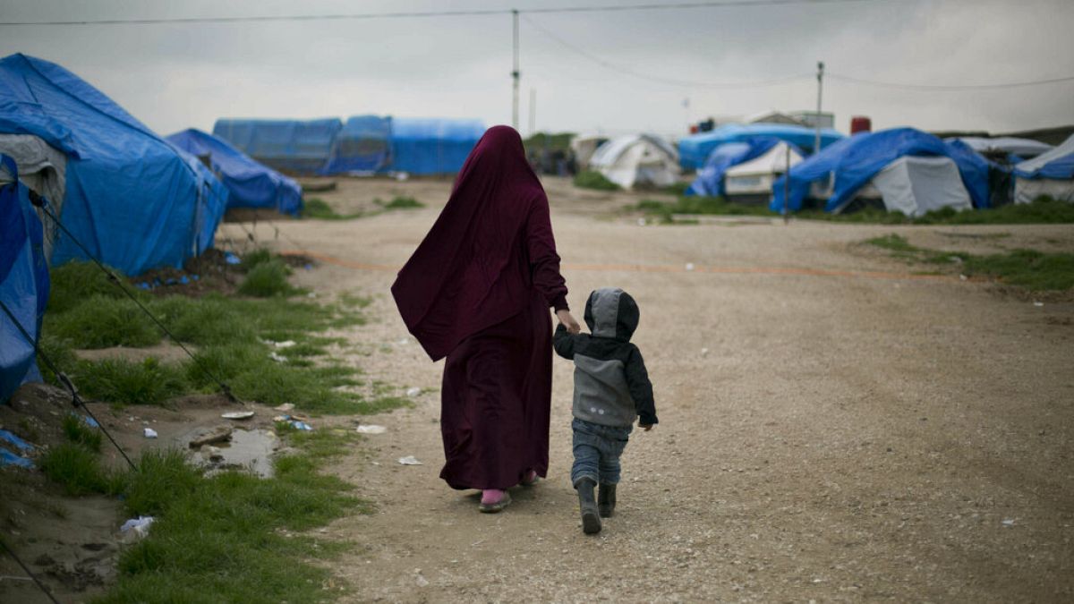 Ezen a 2019 februárjánban készült képen a belga állampolgárságú Samira, aki egy francia IS-taghoz ment feleségül, gyermekével sétál az Al Roj táborban