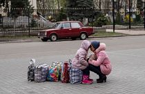 Une mère et sa fille attendent un bus pour fuir la ville de Sloviansk, dans la région de Donetsk, 16 avril 2022.