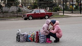 Une mère et sa fille attendent un bus pour fuir la ville de Sloviansk, dans la région de Donetsk, 16 avril 2022. 