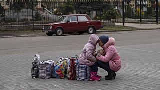 Mãe abraça a filha enquanto esperam pelo autocarro que as levará da cidade de Sloviansk, em Donetsk, Ucrânia