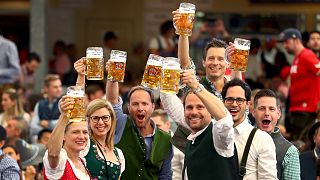 In this Saturday, Sept. 21, 2019 file photo, visitors lift glasses of beer during the opening of the 186th 'Oktoberfest' beer festival in Munich, Germany.