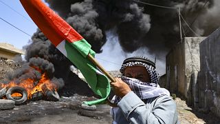 رجل فلسطيني مسن يحمل العلم الوطني في أعقاب مظاهرة ضد مصادرة إسرائيل للأراضي الفلسطينية في قرية كفر قدوم. 2022/07/01