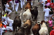 Revellers run next to fighting bulls during the running of the bulls at the San Fermin Festival, in Pamplona, northern Spain, Saturday, July, 13, 2019