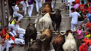 Revellers run next to fighting bulls during the running of the bulls at the San Fermin Festival, in Pamplona, northern Spain, Saturday, July, 13, 2019