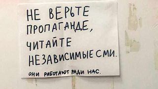 A note reads: "Do not believe the propaganda you see on the TV, read independent media! They work for our sake." outside an apartment in Perm, Russia