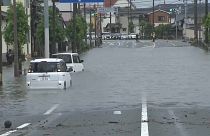 Coches parados, en parte sumergidos en las aguas de la inundación, 5/7/2022, Fukuoka, Japón