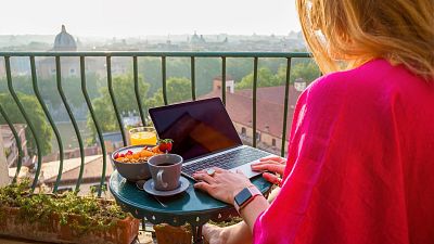 A digital nomad works on a balcony in Rome, Italy.