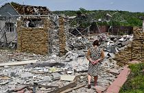 Une femme âgée marche à côté d'un bâtiment détruit par une frappe de missiles à Sloviansk, en Ukraine, mercredi 1er juin 2022.