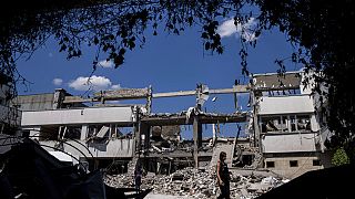 Ukrainian journalists walk in the yard of National Pedagogic university destroyed by a Russian attack in Kharkiv, Ukraine, Wednesday, July 6, 2022.
