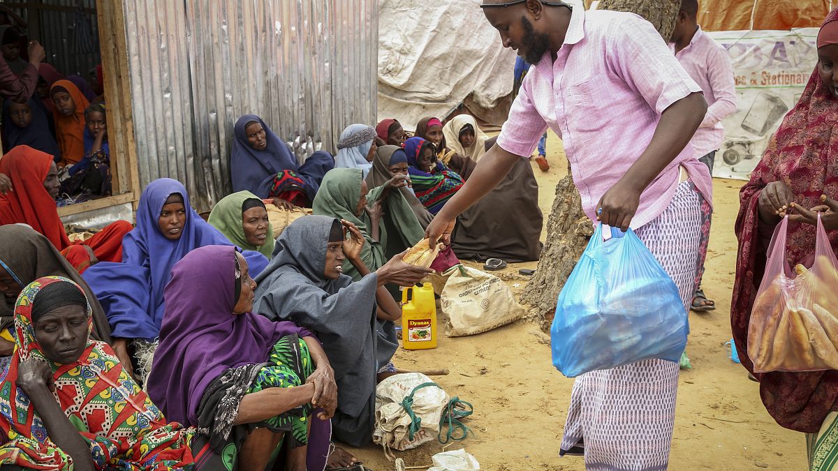 Los somalíes que huyeron de las zonas afectadas por la sequía reciben donaciones de alimentos.