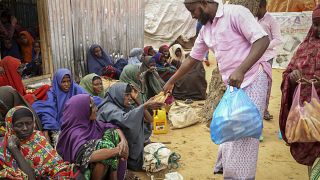 Los somalíes que huyeron de las zonas afectadas por la sequía reciben donaciones de alimentos.