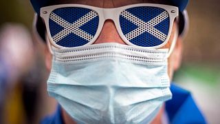 A pro-independence protester wearing a protective face covering to combat the spread of the coronavirus, joins a gathering in George Square, Glasgow 